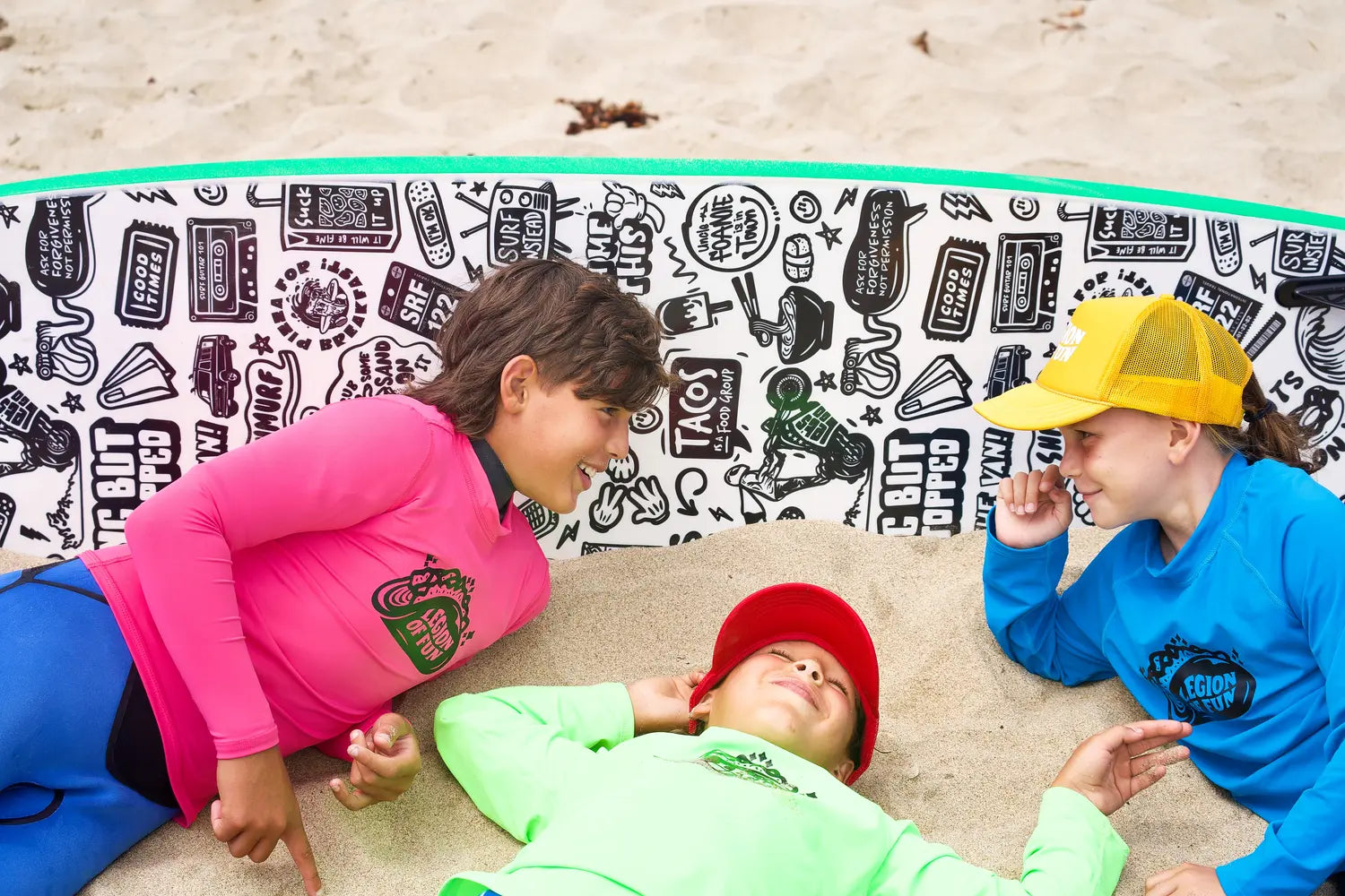 Kids hang out on the beach with the Uncle Foamie Surfboard by Legion of Fun